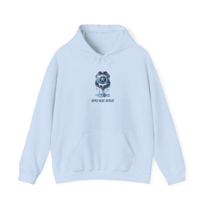 Apply Heat Repeat anti-ICE hoodie by Moral Fabric — melting badge graphic on progressive political streetwear