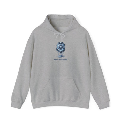Apply Heat Repeat anti-ICE hoodie by Moral Fabric — melting badge graphic on progressive political streetwear